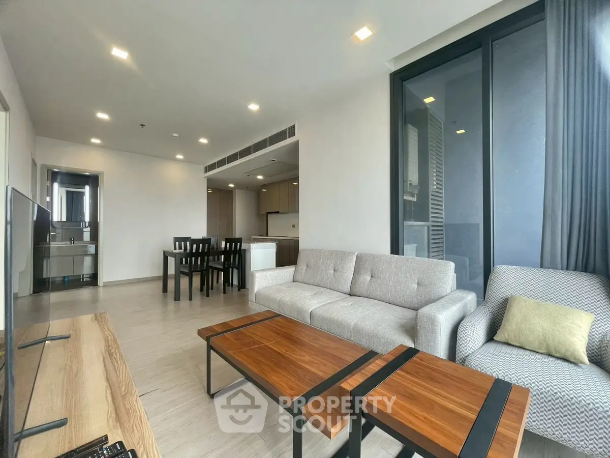 Spacious modern living room with elegant furniture and open kitchen layout in a luxury apartment.