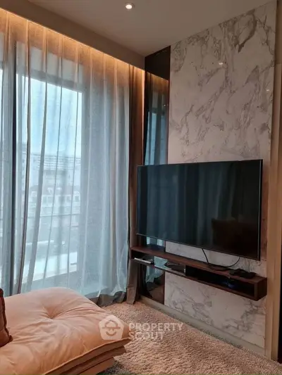 Luxurious living room with modern TV setup and elegant marble wall design.