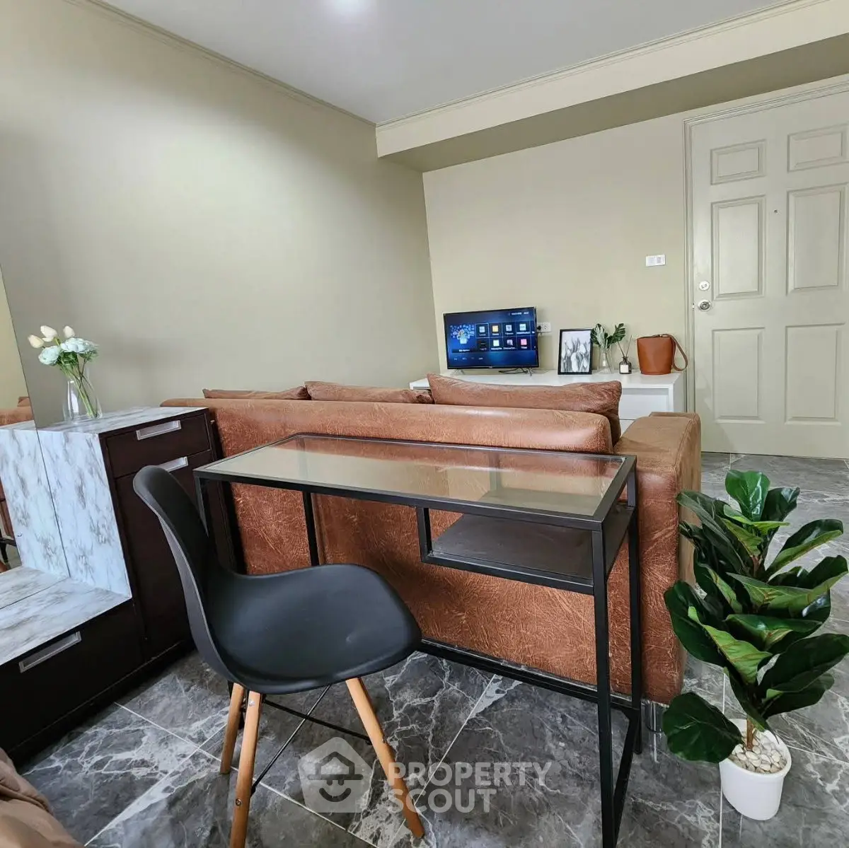 Modern living room with stylish furniture and marble flooring, featuring a cozy sofa and sleek TV setup.
