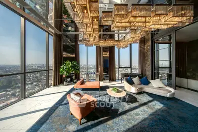 Luxurious high-rise living room with panoramic city views and elegant chandelier.