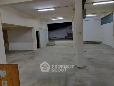Spacious industrial-style open area with concrete floors and high ceilings, ideal for creative workspace or storage.