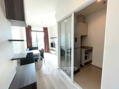 Modern apartment interior with open living room and kitchen, featuring sleek furniture and natural light.
