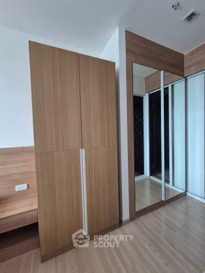 Modern bedroom with wooden wardrobe and mirrored sliding doors