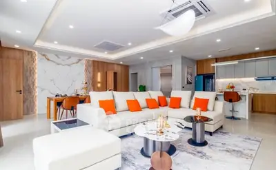 Luxurious modern living room with open kitchen, elegant decor, and spacious seating area.