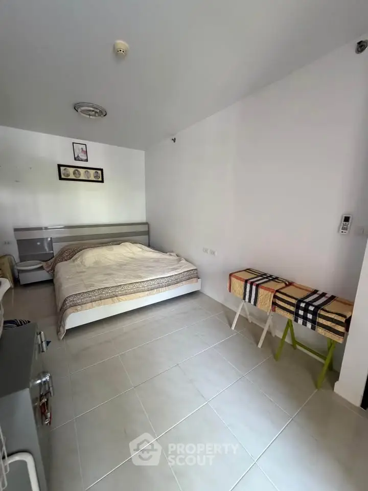 Spacious bedroom with modern decor and tiled flooring, perfect for comfort and relaxation.