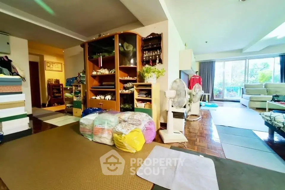Spacious living room with large windows and cozy seating area, perfect for relaxation and entertaining.