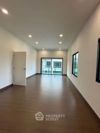 Spacious modern living room with large windows and wooden flooring