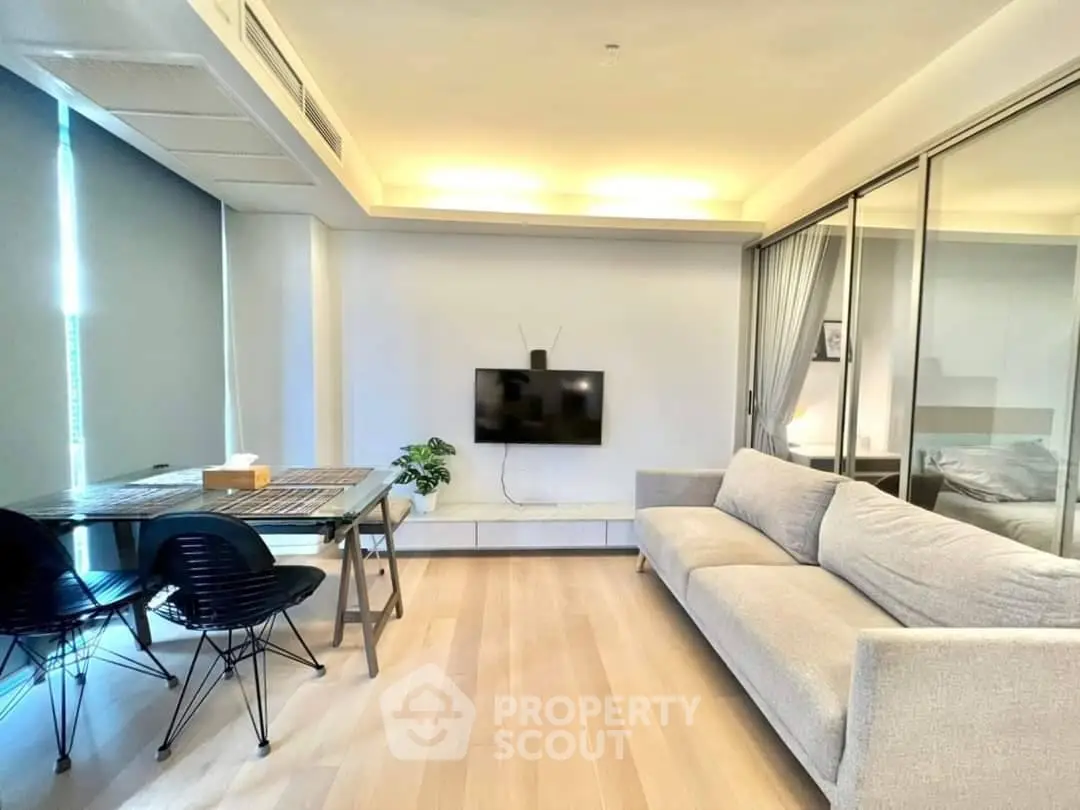 Modern living room with sleek furniture and wall-mounted TV in a stylish apartment.