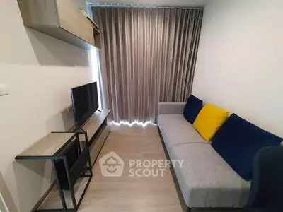 Modern living room with sleek furniture and stylish decor, featuring a cozy sofa and a flat-screen TV.