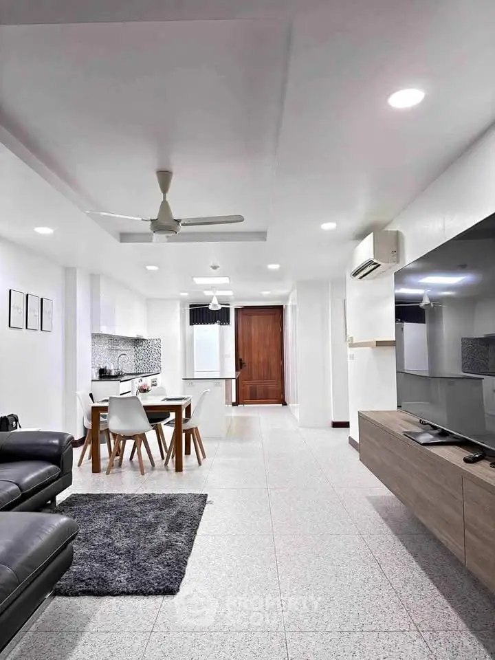 Spacious modern living room with open kitchen layout and sleek furnishings.