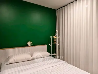 Modern bedroom with green accent wall and elegant white curtains