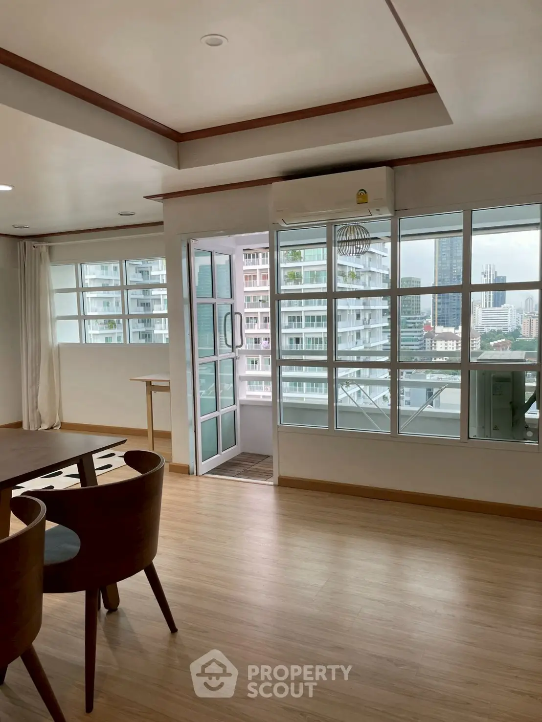 Spacious living room with large windows and city view in modern apartment