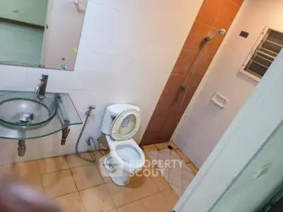 Modern bathroom with glass sink and shower in a real estate property