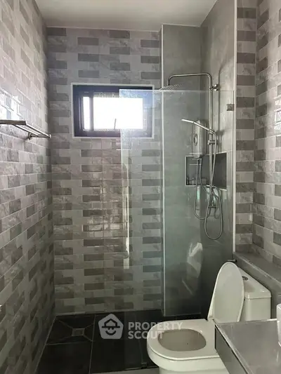 Modern bathroom with glass shower and stylish tile design.