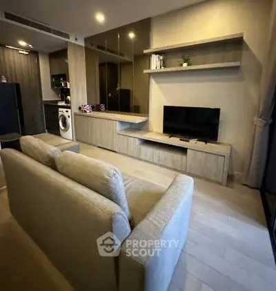 Modern living room with sleek design, featuring a cozy sofa, wall-mounted TV, and built-in shelves.
