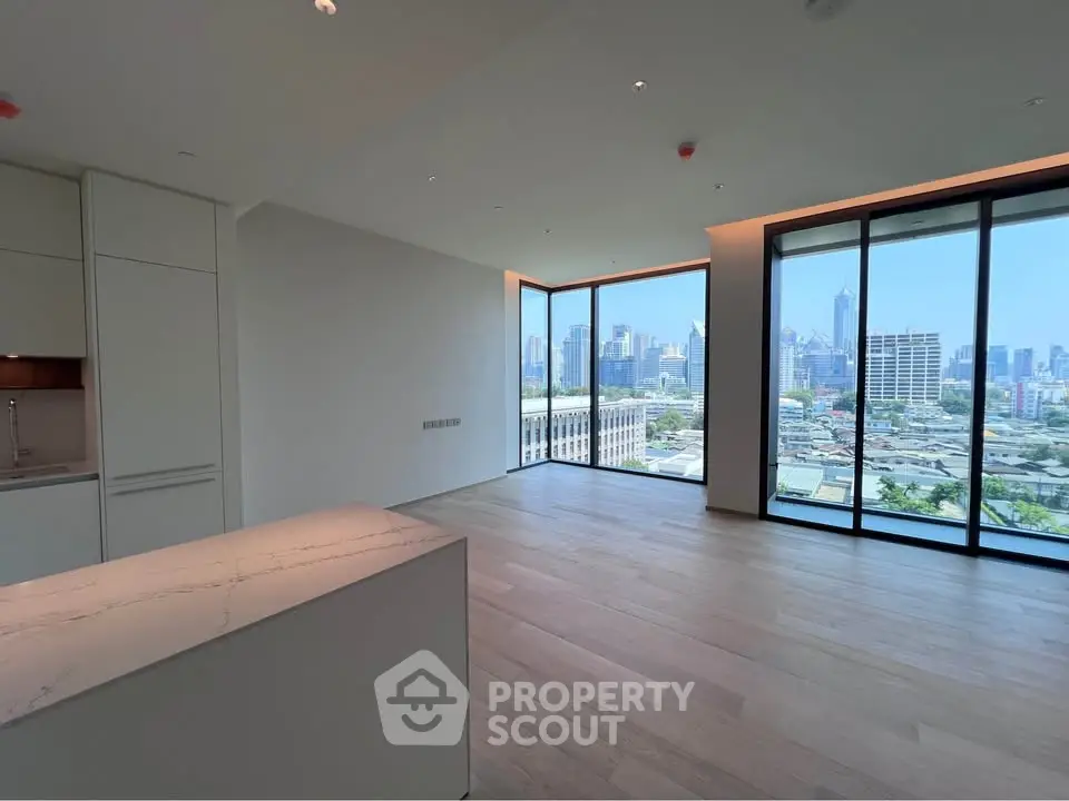 Luxurious open-plan living room with stunning city skyline view through floor-to-ceiling windows.