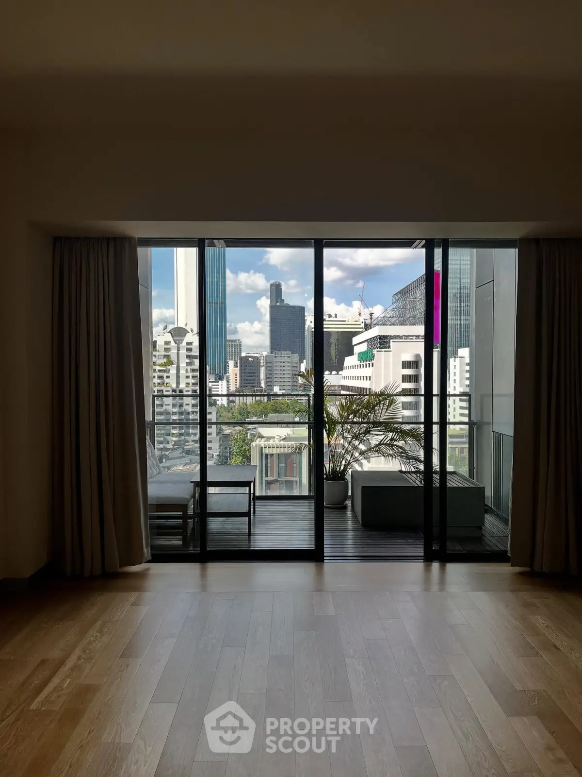 Spacious living room with stunning city view and large balcony access.