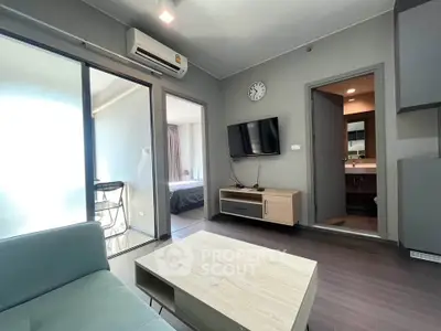 Modern living room with sleek furniture and wall-mounted TV in a stylish apartment.