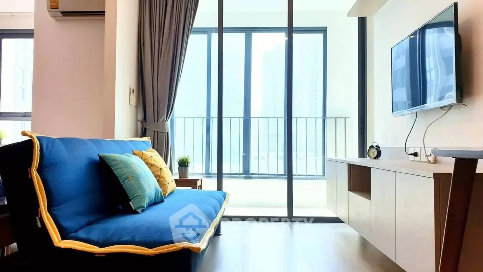 Modern living room with blue sofa and balcony view in high-rise apartment