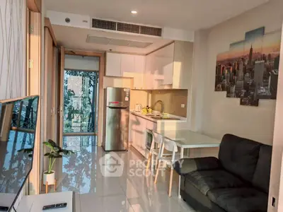 Modern open-layout kitchen and living area with stylish decor and natural light.