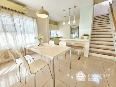 Modern dining area with sleek table, chairs, and stylish lighting in a bright, airy home.