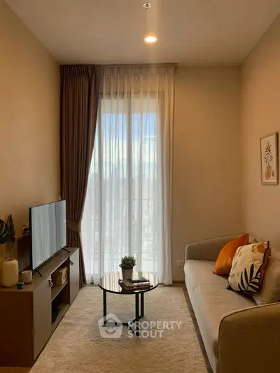 Cozy living room with modern decor and natural light through large window.