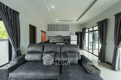 Modern living room with plush gray sofa and open kitchen layout