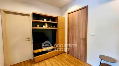 Modern living room with wooden flooring and built-in TV unit