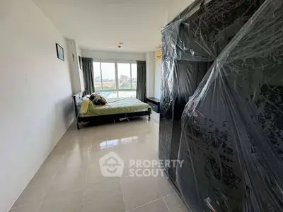 Spacious bedroom with large window offering scenic views and modern furnishings.