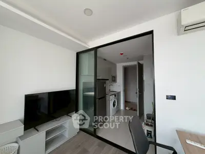 Modern apartment interior with TV, washing machine, and air conditioning.