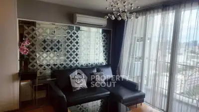 Stylish living room with modern decor and city view, featuring a sleek black sofa and decorative mirror wall.