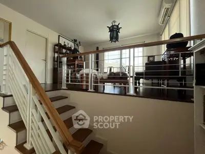 Elegant living room with wooden flooring and stylish decor, featuring a cozy seating area and natural light.
