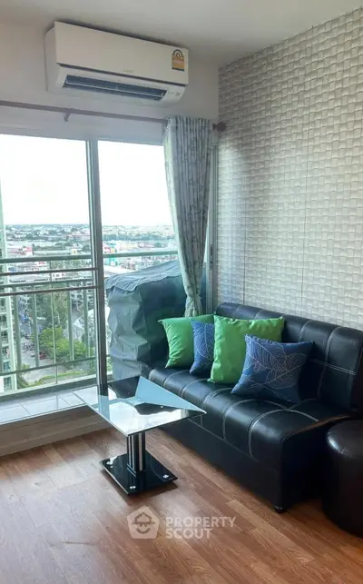Modern living room with city view, featuring a sleek black sofa and stylish decor.