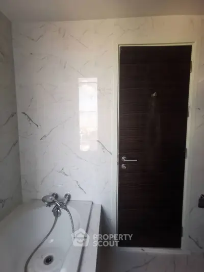 Modern bathroom with elegant marble walls and sleek bathtub design