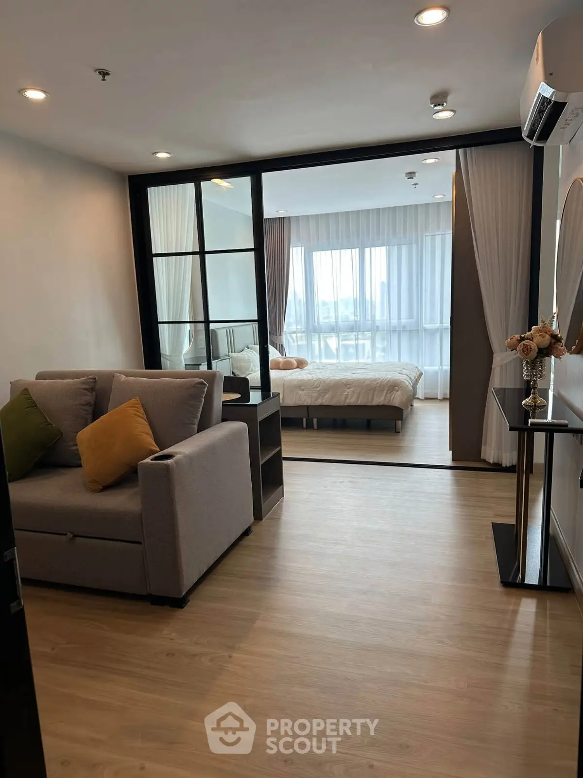 Modern apartment with cozy living room and stylish bedroom, featuring elegant decor and natural light.