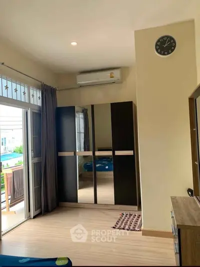 Spacious bedroom with balcony access and modern wardrobe in a stylish apartment.