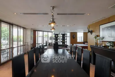 Luxurious dining room with elegant decor and large windows offering natural light and garden view.