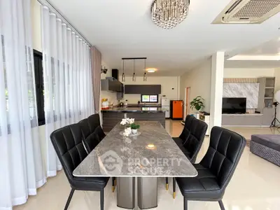 Luxurious open-plan kitchen and dining area with elegant marble table and modern lighting.