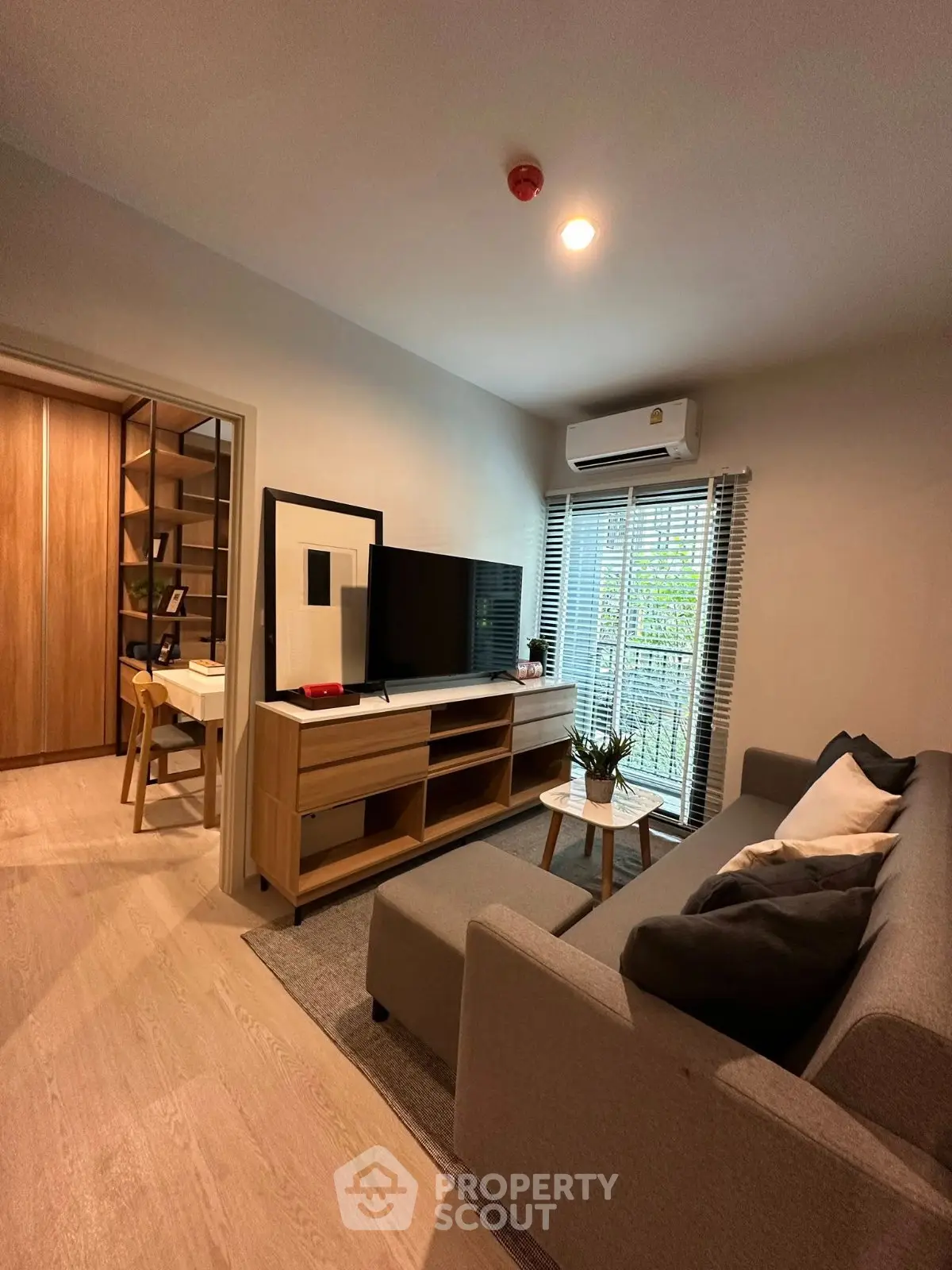 Modern living room with stylish furniture and natural light from large windows.