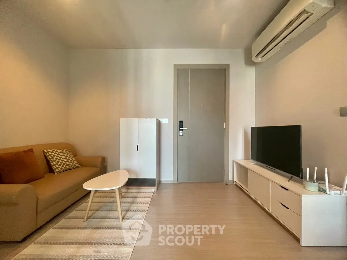 Modern living room with cozy sofa, sleek TV unit, and air conditioning.