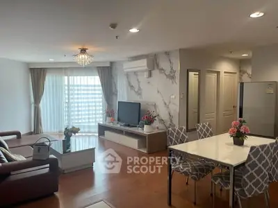 Spacious modern living room with elegant decor and dining area, featuring a large window for natural light.