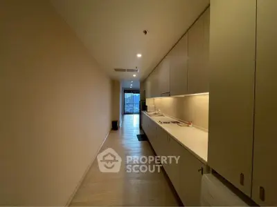 Spacious hallway with modern cabinetry leading to a bright living area in a contemporary apartment.