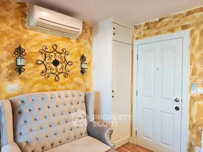 Charming living room with elegant wall decor and cozy seating, featuring a stylish air conditioning unit.