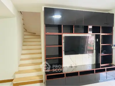 Modern living room with built-in TV unit and staircase