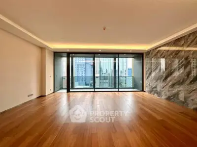 Spacious modern living room with hardwood floors and city view balcony