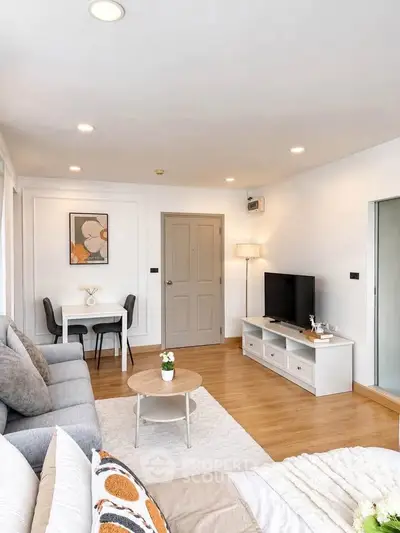 Modern living room with stylish decor, cozy seating, and a sleek entertainment center.