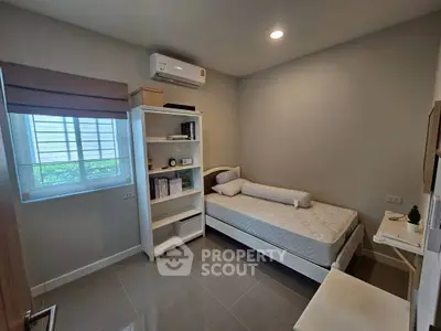 Cozy bedroom with modern furnishings and ample natural light, perfect for a peaceful retreat.