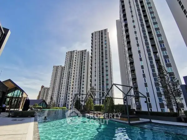 Luxurious high-rise apartment complex with stunning pool and modern architecture.