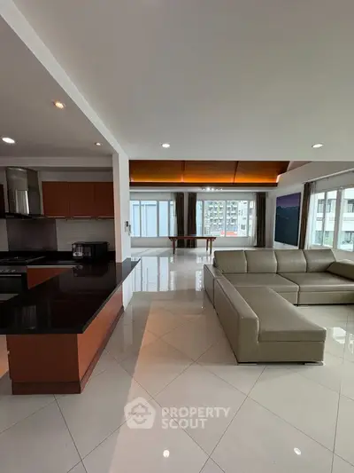 Spacious open-plan living room with modern kitchen and large windows