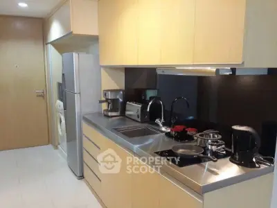 Modern kitchen with stainless steel appliances and sleek cabinetry in a contemporary apartment.